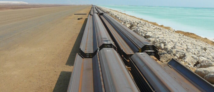 Aufgereihte Larssen Spundwandbohlen am Strand.