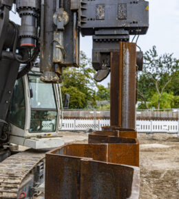 Einbringung von Hoesch Spundbohlen in den Boden mithilfe von einer freireitenden Maschine.